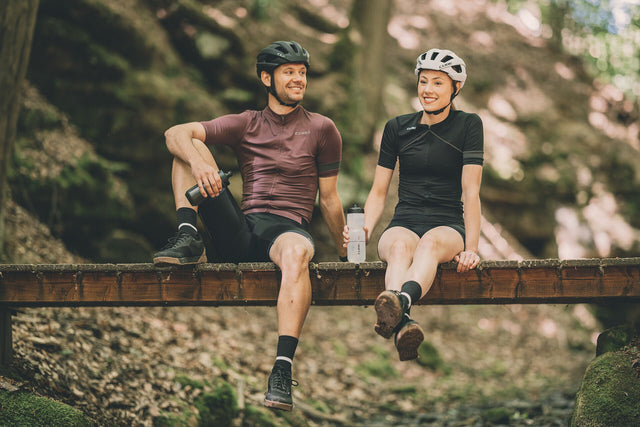 Vrouw met fiets en CUBE Fietskleding